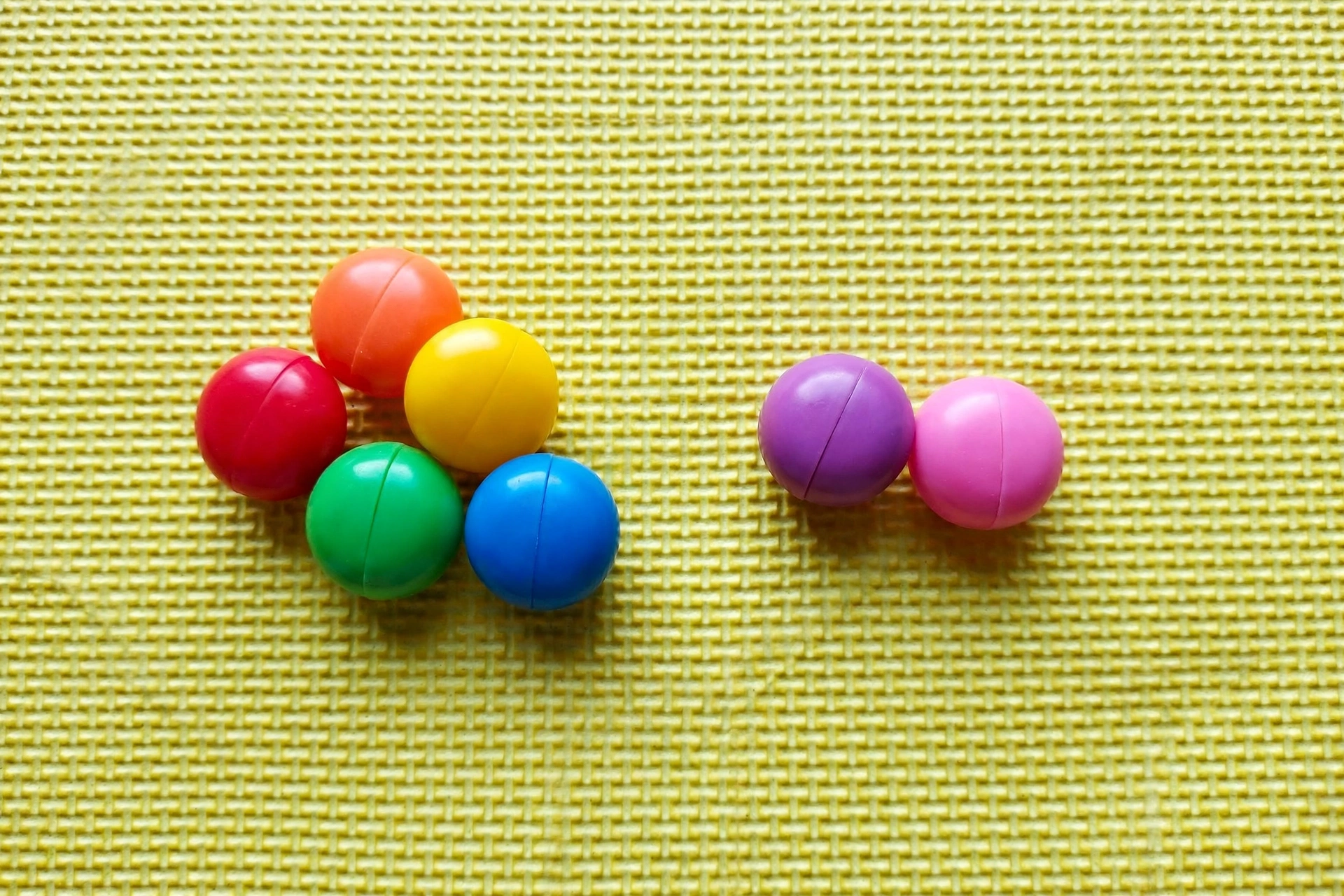 Seven counters split into a group of 5 and a group of 2 on a colorful mat